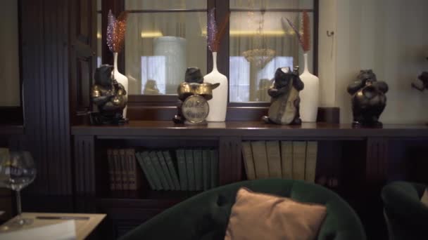 Zicht op mooie interessante luxe interieur van het restaurant met boeken, dierenfiguren met muziekinstrumenten. — Stockvideo