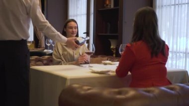 Restoranda oturan arkadaşlar sipariş ve kırmızı şarap ile Garson geliyor ve tam gözlük için bekliyor