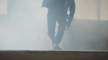 Terk edilmiş binasında duman bulutu performans spor giyim tanınmaz hip-hop erkek dansçı bacaklar. Hamle yapmak, atlama ve etrafında dönen adam... Ağır çekim