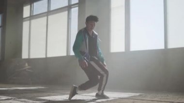 Terk edilmiş bir binada dans yetenekli genç çekici rapçi. Çağdaş. Hip hop kültürü. Prova. Ağır çekim.