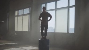 Terk edilmiş bir binada bir varil üzerinde dans ustaca sokak dansçı hip-hop. Çağdaş. Hip hop kültürü. Prova. Ağır çekim.