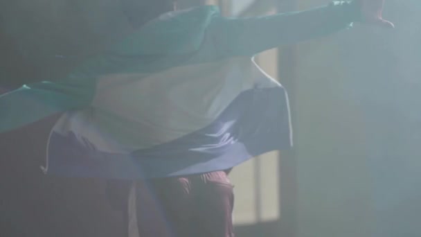 Mladý asijské hip-hop mužský tanečník, tanec ve tmě opustili budovu v přední části modré palivové. Muž, aby se pohybuje a skákání. Zpomalený pohyb — Stock video