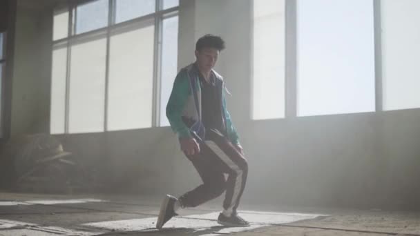 Jeune rappeur habile et séduisant dansant dans un bâtiment abandonné. Contemporain. Culture hip hop. Répétition. Mouvement lent . — Video