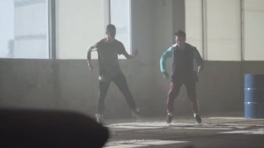 İki çocuğu terk edilmiş binada büyük pencerenin önünde dans. Gençler dans aynı anda hareket yapma. Çocuklar breakdance içinde pratik. Hip hop kültürü. Prova. Çağdaş.