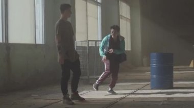 Varil yakın terk edilmiş bir binada iki sokak dansçıları dans savaşı. Hip hop kültürü. Prova. Çağdaş.