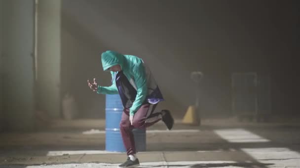 Experimentado joven bailarín de hip-hop bailando cerca del barril en un edificio abandonado en la niebla. Cultura hip hop. Ensayo. Contemporáneo . — Vídeo de stock