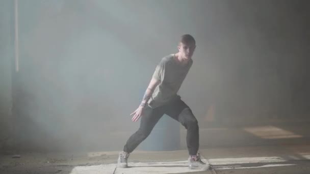 Skickliga unga passionerade rap dansare utför. Mannen sträcker armarna framåt, därefter gör skarpa rörelser till sidorna med hela kroppen. Repetitionen. — Stockvideo