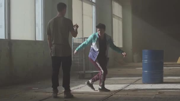 Hip hop kulturen. Repetitionen. Samtida. Dans slaget två street dansare i en övergiven byggnad nära fat. — Stockvideo