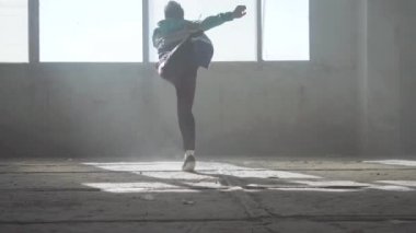 Terk edilmiş bir binada dans yetenekli genç adam. Hip hop kültürü. Prova. Çağdaş. Bir flip ile dans.