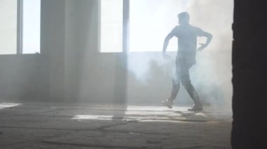 Yetenekli genç tutkulu hip-hop dansçısı kamera önünde gerçekleştirme kapatın. Adam kollarını ileri uzanır, sonra keskin kenarlara ile tüm vücut hareketleri yapar. Prova.