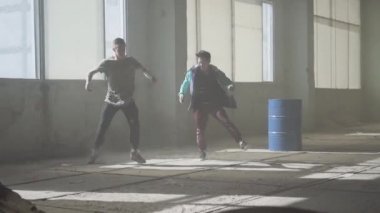 Yetenekli kalça zavallıların eğitim. İki adam başarılı dansçı breakdance tozlu terk edilmiş bir binada dans ediyor. Çağdaş. Hip hop kültürü. Prova.