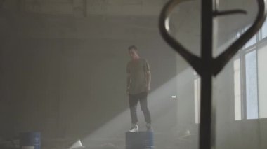 Terk edilmiş bir binada bir varil üzerinde dans sokak dansçısı hip-hop. Çağdaş. Hip hop kültürü. Prova.