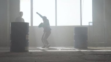 Varil yakın terk edilmiş bir binada iki sokak dansçıları dans savaşı. Hip hop kültürü. Prova.