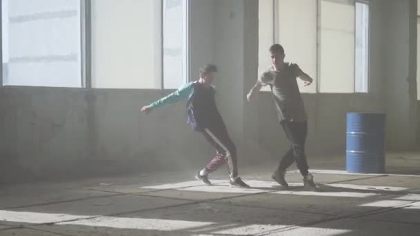Twee vrienden van succesvolle dansers dansen breakdance in een stoffige verlaten gebouw. Hedendaagse. Hip hop cultuur. Repetitie. — Stockvideo