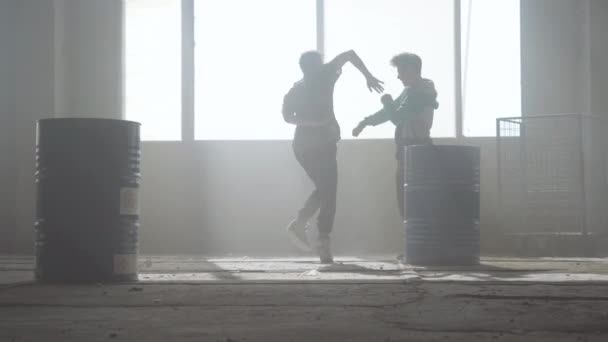 Bataille de danse urbaine de deux danseurs de rue dans un bâtiment abandonné près du tonneau. Culture hip hop. Répétition . — Video