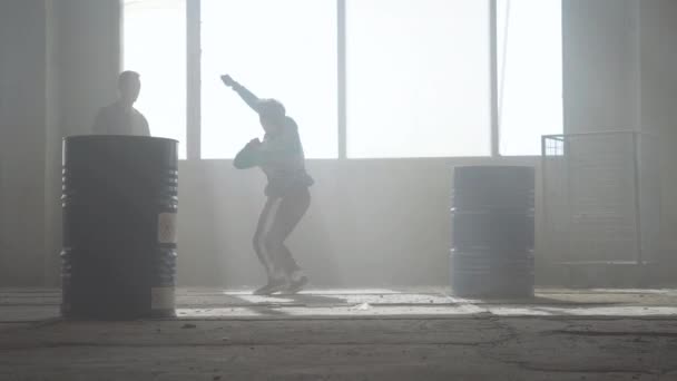 Bataille de danse de deux danseurs de rue dans un bâtiment abandonné près du tonneau. Culture hip hop. Répétition . — Video