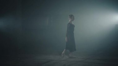 Profesyonel Balerin Bale ayakkabıları dans ve siyah bir arka plan üzerinde spot stüdyoda Black elbise. Genç güzel Bale dansçısı eğitim ve havada bölünmüş performans atlar