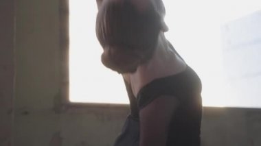 Klasik Bale portre genç zarif balerin dans unsurları yakın yukarı. Arka planda gün batımı ile pencere.