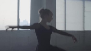 Stüdyo, arka planda gün batımı ile pencere siyah elbise dans profesyonel balerin portresi. Genç güzel Bale dansçısı ayak üzerinde alır ve eller yetiştirmek etrafında Spinning