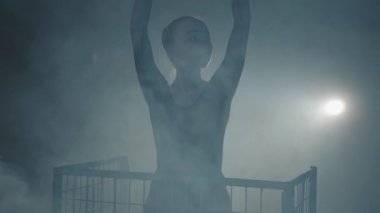 Portre profesyonel balerin siyah bir arka planda spot dans. Genç güzel kadın yükselen el ve kafes üzerinde elini sallayarak