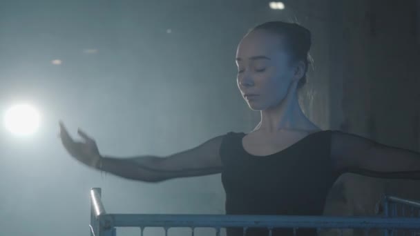 Close up portrait professional ballerina dancing in spotlight on a black background. Young beautiful woman rising hand and waving her hand above the cage — Stock Video