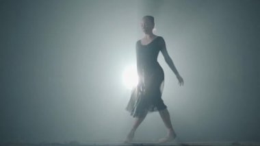 Profesyonel balerin stüdyo siyah arka plan üzerinde Spotlight onun Pointe bale ayakkabıları üzerinde dans. Bale dansçısı klasik bale pas gösterir.