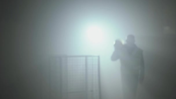 Retrato del trabajador en el uniforme de los constructores y el casco sobre un fondo negro en el centro de atención en el lugar de trabajo . — Vídeos de Stock