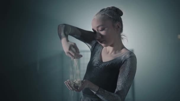 Portrait d'une jeune ballerine talentueuse et gracieuse en robe noire arquée et lançant de la farine. Mouvement lent . — Video