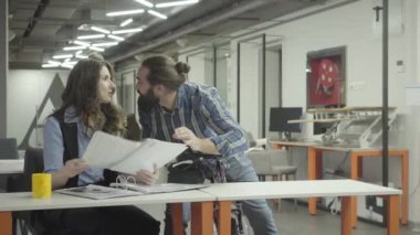 Güzel kadın ve yakışıklı sakallı adam ofiste iletişim, gülüyor. Beardie, bisikletini tutan bir bayanla duygusal olarak bilgi tartışıyor. Meslektaşları gülümseyen ve olumlu. Işyeri.