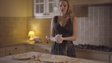 Siyah elbiseli portre oldukça baştan çıkarıcı kadın El karıştırma hamur un ile bulaşmış. Yavaş hareket.