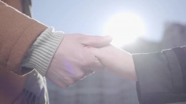 İnsan ve kadın eller kentsel Cityscape önünde yakın. Onun kız arkadaşı eşi el tutan adam bizim kapılar, arka planda gün batımı. Aşk kavramı, duygular, hassasiyet. Yavaş hareket