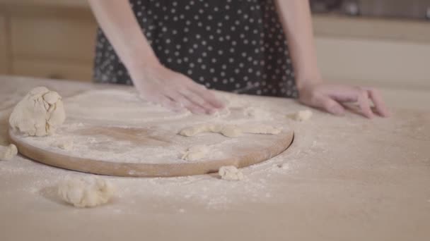 Donna non riconosciuta in abito nero spalmato di farina mescolando la pasta nelle mani. Rallentatore . — Video Stock