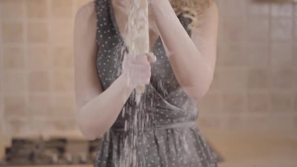 Retrato de mujer no reconocida en vestido negro frota rodillo con harina. Chica apasionada preparando masa en la cocina en casa . — Vídeos de Stock