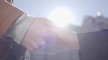 İnsan ve kadın eller kentsel Cityscape önünde yakın. Onun kız arkadaşı eşi el tutan adam bizim kapılar, arka planda gün batımı. Aşk kavramı, duygular, hassasiyet. Yavaş hareket