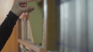 Kadın el kitaplık bir kitap çekerek yakın yukarı.