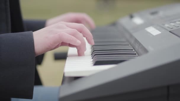 Félreismert lány szenvedélyes játék szintetizátor és énekel ül a fa alatt a kertben a szabadban. Romantika, meditáció, elektronikus zene — Stock videók