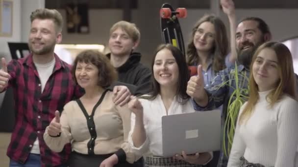 Portret duży przyjazny zespół biurowy uśmiechnięty i pokazując duże palce patrząc w aparacie, stojąc w dużej sali biurowej. Koncepcja nowoczesnego miejsca pracy. — Wideo stockowe