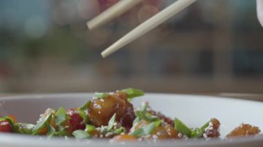El Chopsticks yakın yukarı kullanarak plaka bal lezzetli tavuk huzur alır. Çin restoranında akşam yemeği. Lezzetli iştah açıcı sağlıklı gıda. Mercimek ile salata, soya lahanası ve kurutulmuş Dana eti.