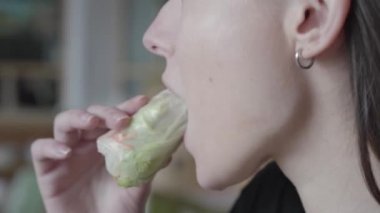 Tatlı yiyen genç kadının yüzünü yakın. Muz yay ruloları. Gevrek breading muz hamuru tamamlar.