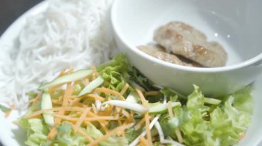 Erişte ve havuç, salatalık ve marul vitamini salata yakın plaka üzerinde kase yalan cutlets. Aşçı restoranda hizmet için yiyecek hazırlar