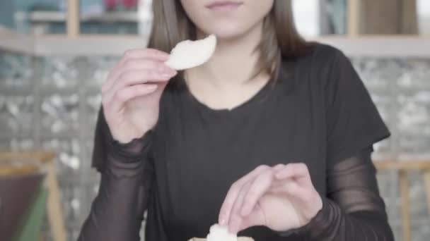 Beautiful brunette girl eats delicious thin bread or crispy breading. — Stock Video