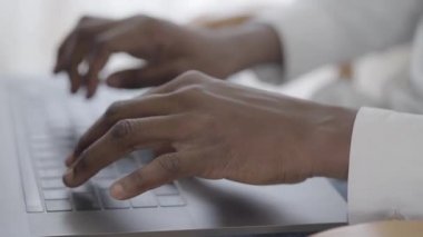 Çekici Afican Amerikan kadın onu kadar gün laptop yazarak e-posta ile çalışmaya odaklanmış. Yakın çekim.