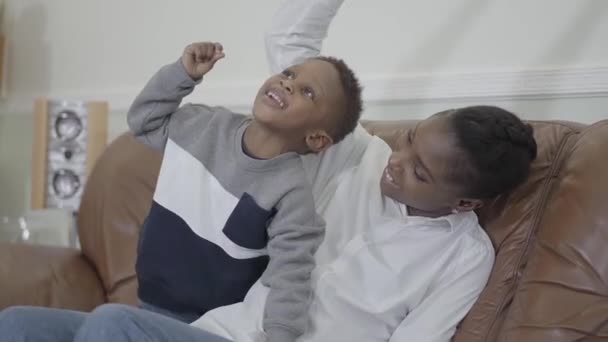 Afrikansk amerikansk attraktiv mamma leker och ha kul med söt son som ger honom choklad bit kaka — Stockvideo