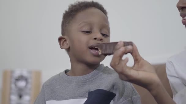 非洲裔美国人有吸引力的母亲玩和有乐趣与可爱的儿子给他巧克力一块蛋糕 — 图库视频影像