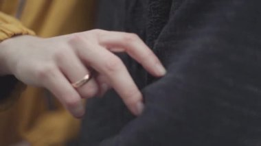 Kadın parmaklar bir kazak yakın bir erkek elinde yürüyüş.