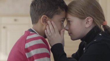 Yakışıklı afro-amerikan erkek ve güzel sarışın beyaz kız alnına dokunmadan portre. Çocuklar dokunsal duyumlar kullanarak birbirlerini tanırlar. Kız elleriyle erkek yüz tutun