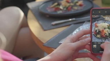 Masada süslemeleri ile taze ağız sulandıran sebze çanak akıllı telefon fotoğraf çekmek Kadın el.