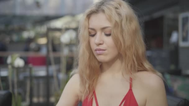 Portre sevimli sarışın kadın kıvırcık saçlı restoranda pasta yeme yakın. Derin dekoltesi olan seksi bayan yemeğinin tadını çıkarıyor. Kamera yukarı hareket ediyor — Stok video