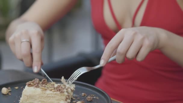 Ελκυστική ξανθιά γυναίκα με σγουρά τούρτα που τρώνε μαλλιά στο εστιατόριο κοντά. Η καυτή κυρία με το βαθύ ντεκολτέ απολαμβάνει το φαγητό της. Η κάμερα μετακινείται — Αρχείο Βίντεο