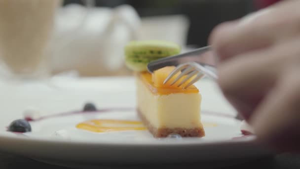 Mano femenina con cuchillo y tenedor cortando un trozo fresco de turquesa crema turquesa turrón y pastel de nueces. De cerca. . — Vídeos de Stock